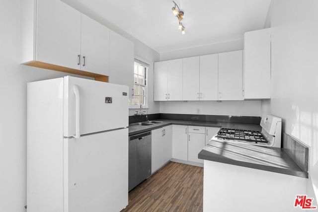 a white refrigerator freezer sitting inside of a kitchen with stainless steel appliances