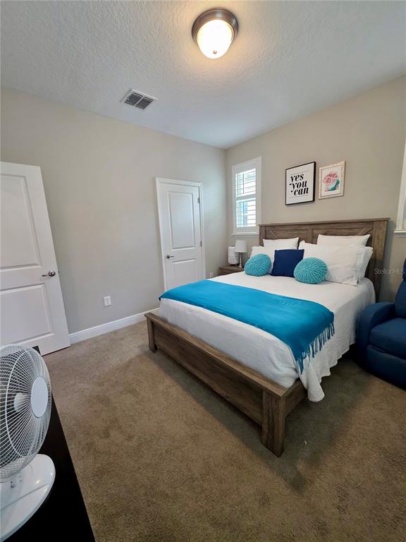 8582 Powder Ridge Trail Windermere, FL 34786 - Photo 42 of 50 a bedroom with a bed and painting on the wall