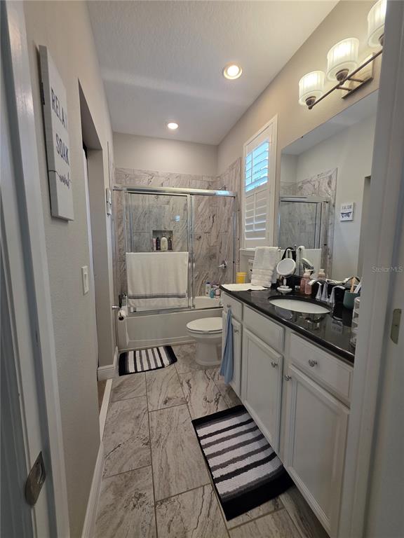 8582 Powder Ridge Trail Windermere, FL 34786 - Photo 44 of 50 a bathroom with a sink a toilet a mirror and shower