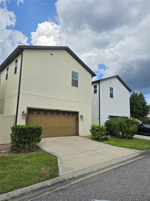 8582 Powder Ridge Trail Windermere, FL 34786 - Photo 47 of 50 a white house with a small yard plants and a large tree