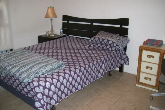 a bedroom with a bed and a night stand