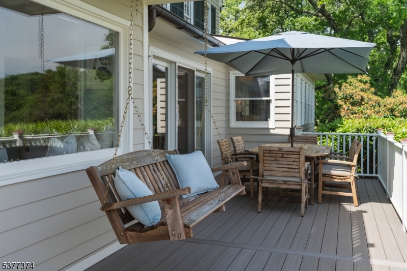 23 Spring Hill Road Annandale, NJ 08801 - Photo 15 of 48 a view of a patio with a table and chairs under an umbrella with wooden floor