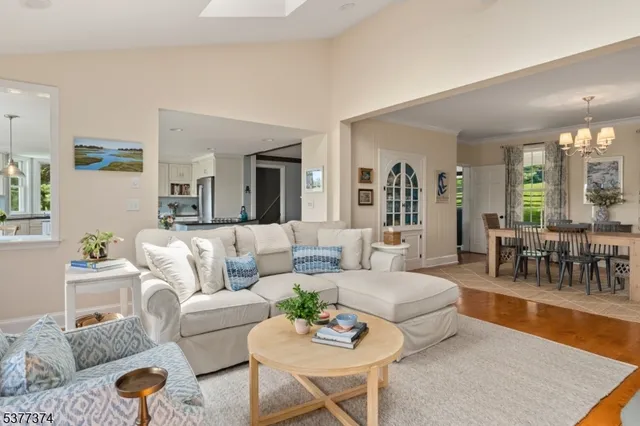 a kitchen with a dining table chairs sink and wooden floor
