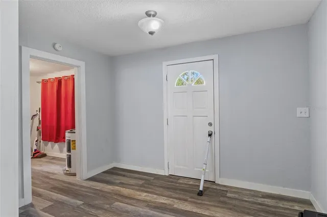 an entryway to room with wooden floor
