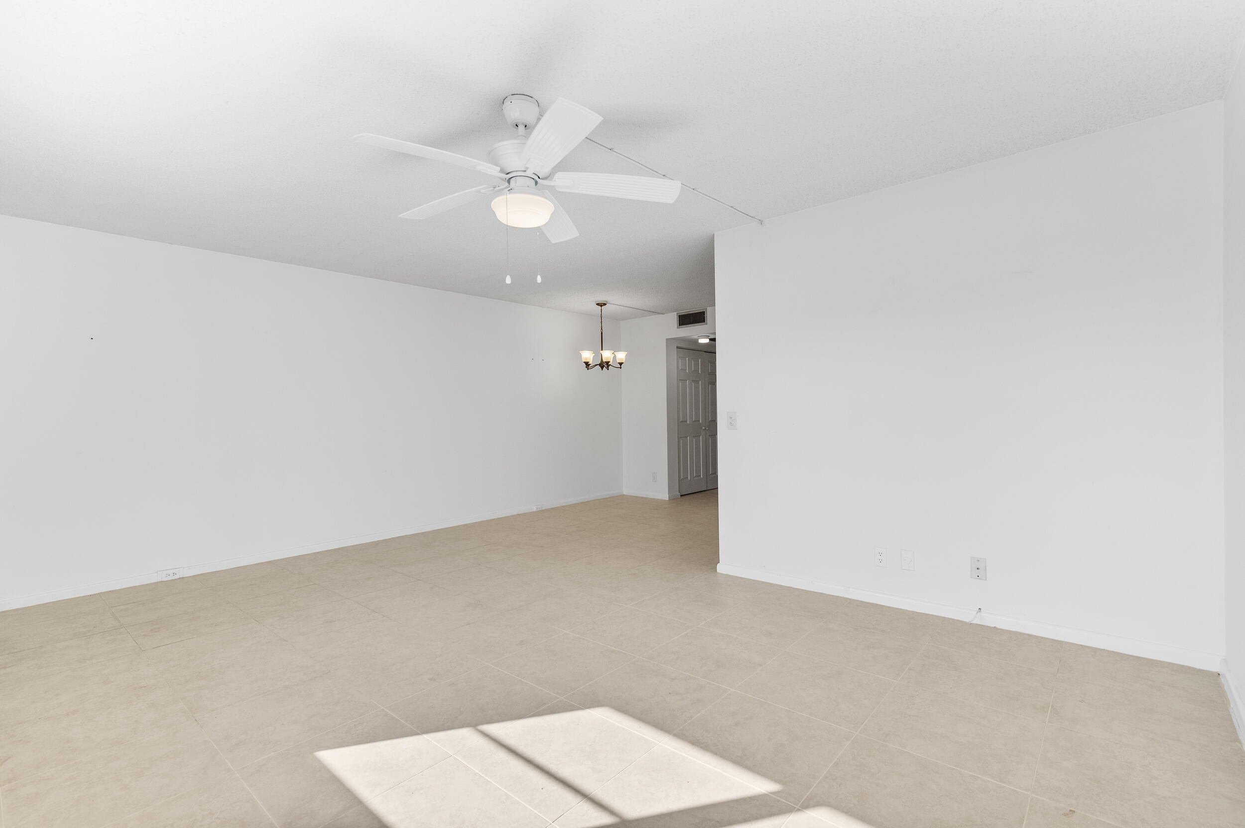 3089 Cornwall East, Unit E Boca Raton, FL 33434 - Photo 11 of 39 an empty room with a ceiling fan and a window