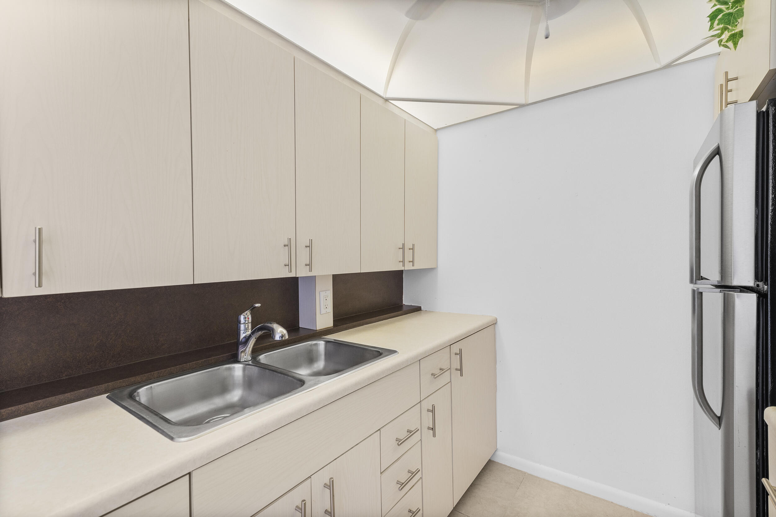 3089 Cornwall East, Unit E Boca Raton, FL 33434 - Photo 15 of 39 a kitchen with a sink cabinets and refrigerator