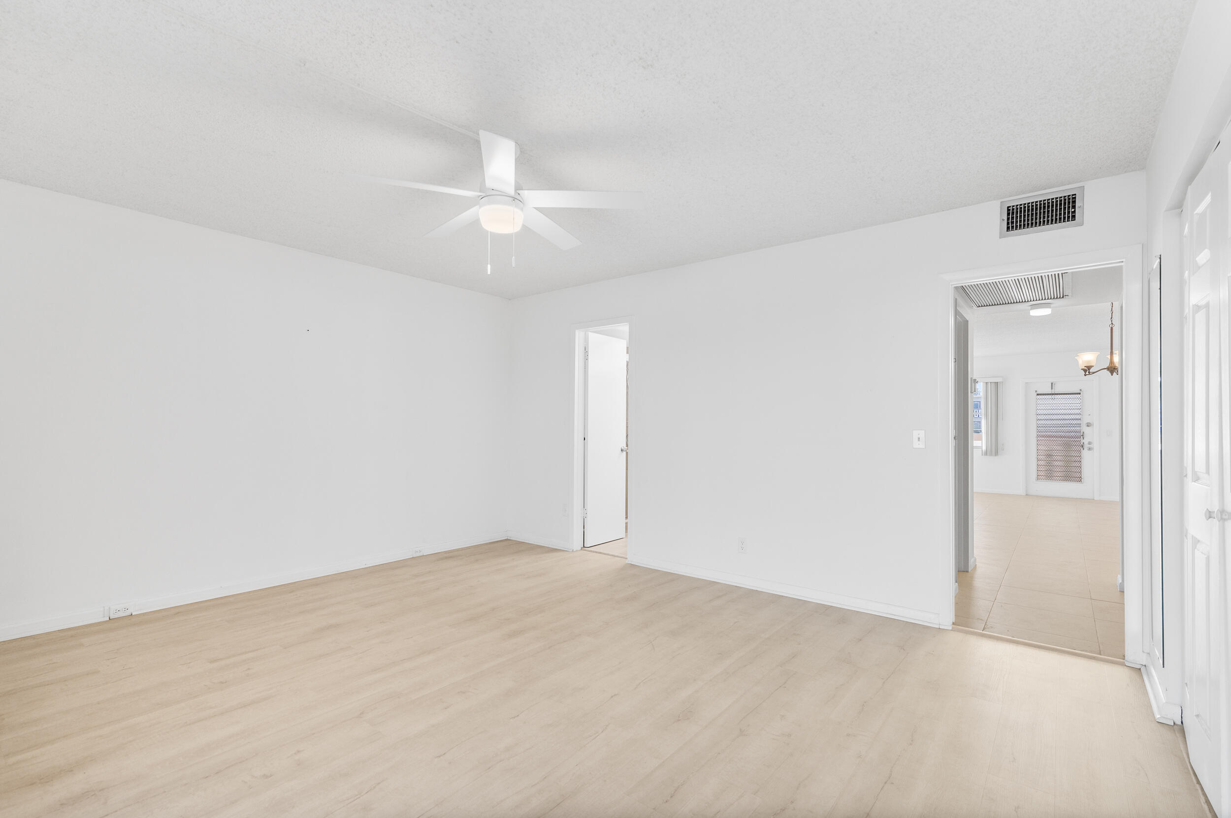 3089 Cornwall East, Unit E Boca Raton, FL 33434 - Photo 19 of 39 an empty room with fan and entrance