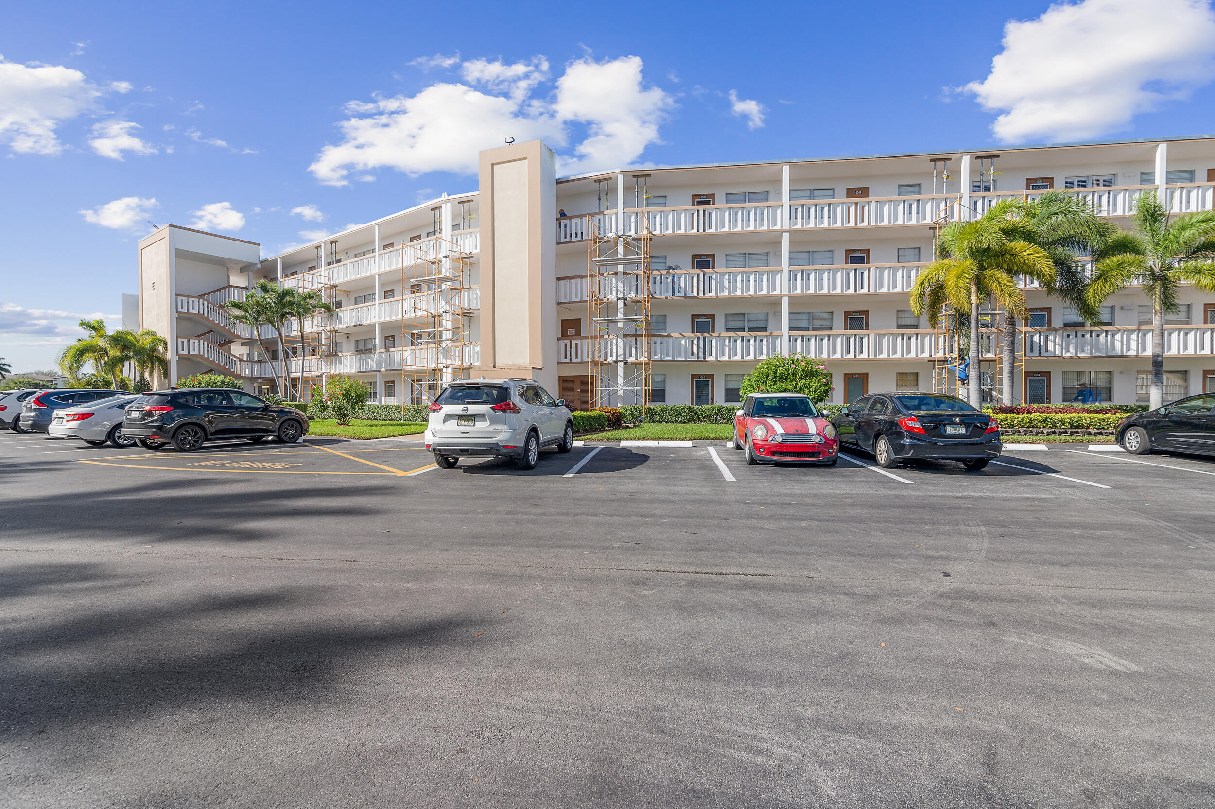 3089 Cornwall East, Unit E Boca Raton, FL 33434 - Photo 30 of 39 a car parked in front of a building with cars parked