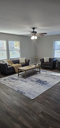 a living room with furniture window and a wooden floor