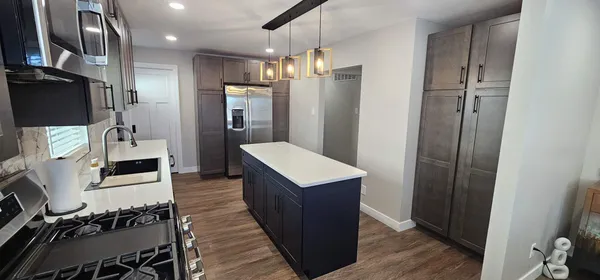 a kitchen with a refrigerator and wooden floor