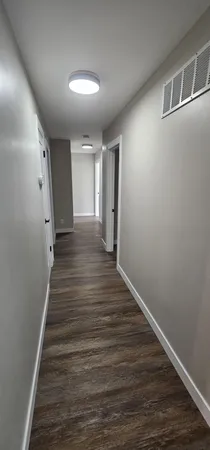 a view of a hallway with wooden floor