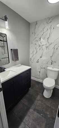 a spacious bathroom with a toilet sink and mirror