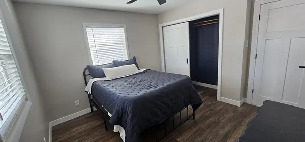 a bedroom with a bed and wooden floor