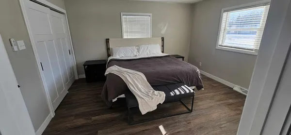 a bedroom with a bed and wooden floor