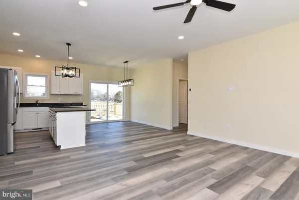 an open kitchen with a refrigerator wooden floor and a window