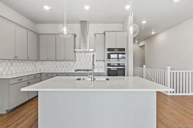 a large kitchen with cabinets a sink and stainless steel appliances