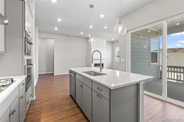 a view of an empty room with wooden floor fireplace and a window