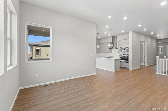 a view of an empty room with wooden floor