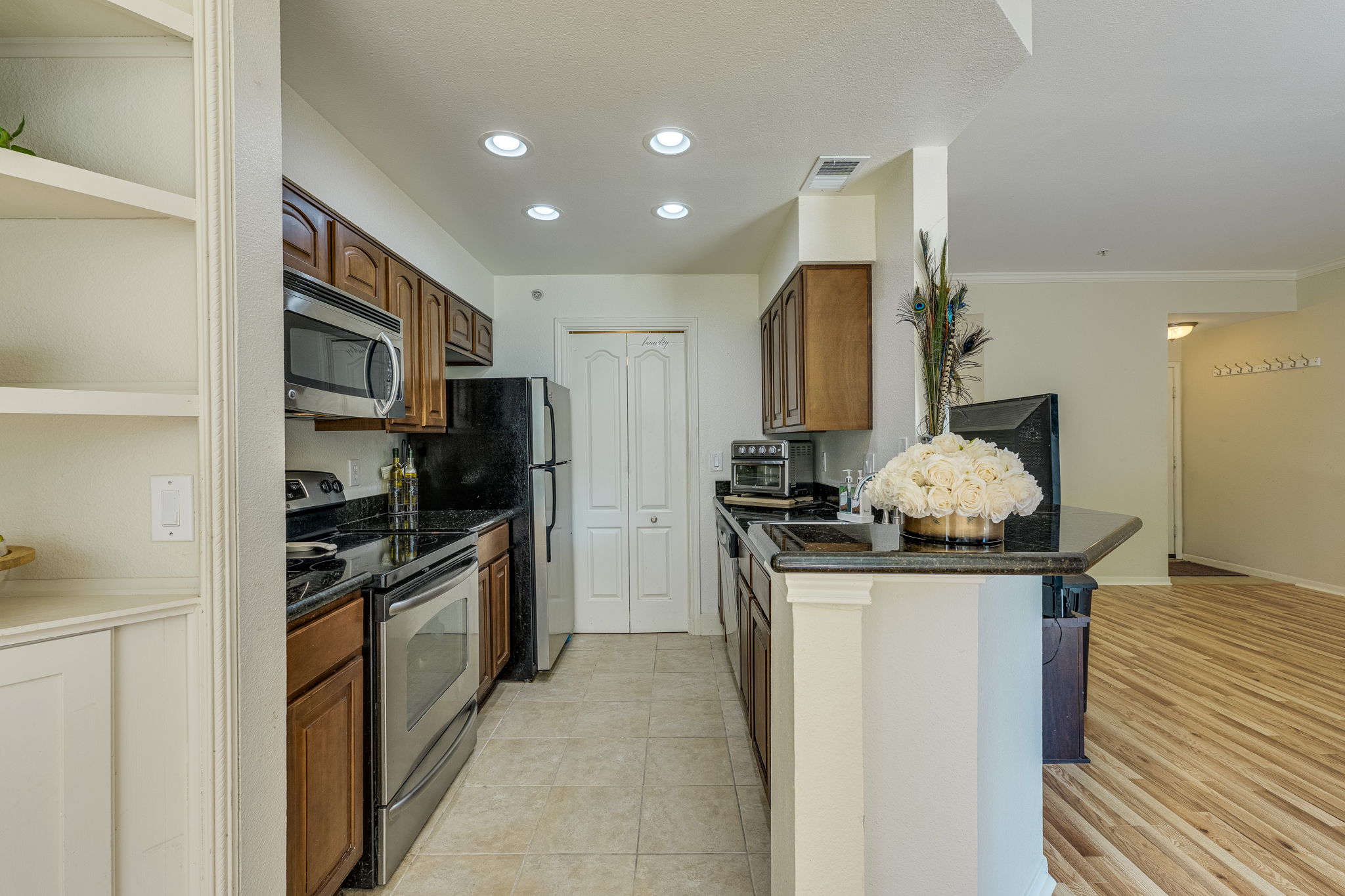 6000 Shepherd Mountain Cove, Unit 807 Austin, TX 78730 - Photo 11 of 38 Kitchen with stainless steel appliances, recessed lighting, granite countertops and brown cabinets.