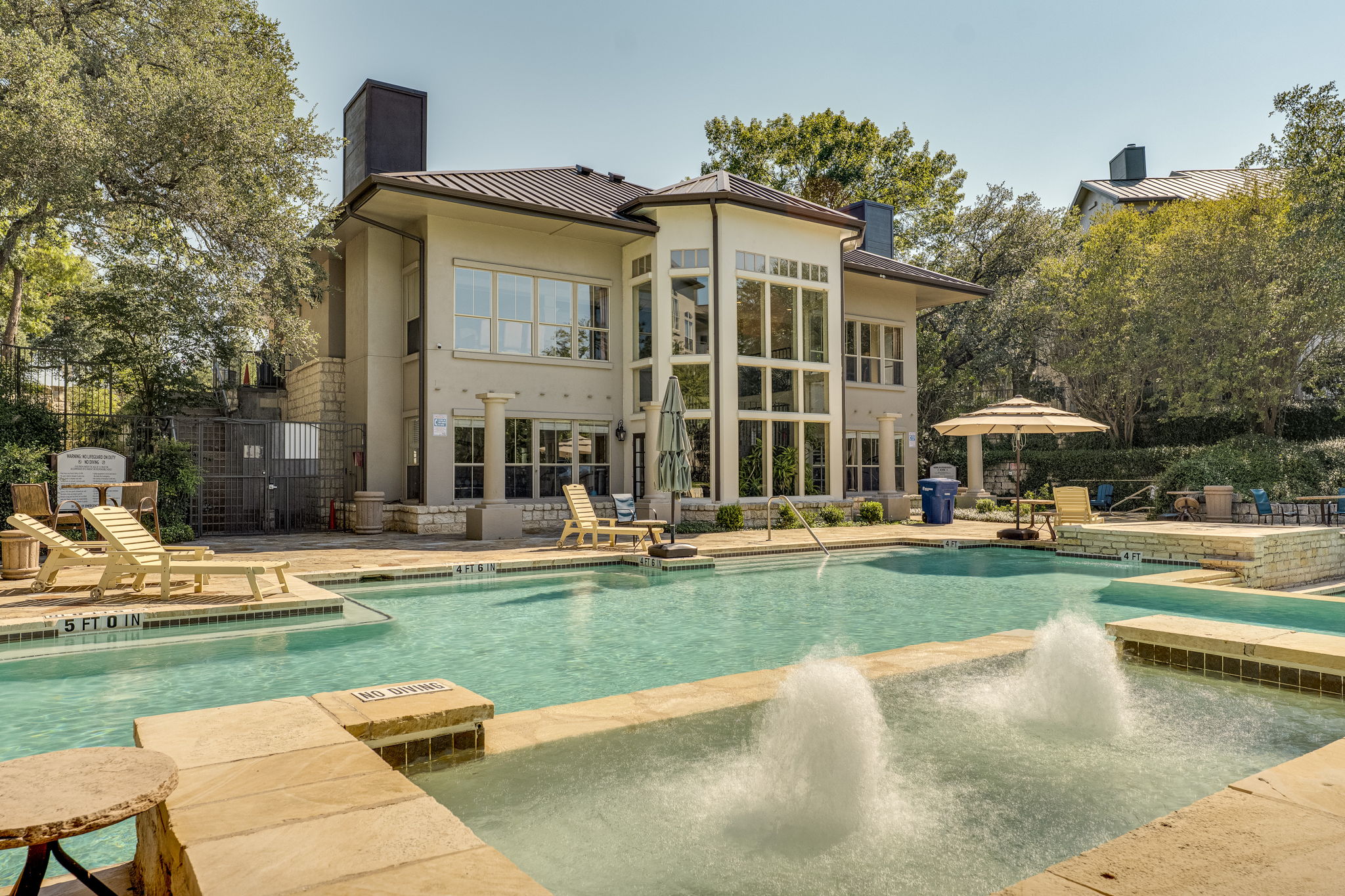 6000 Shepherd Mountain Cove, Unit 807 Austin, TX 78730 - Photo 30 of 38 Rear view of clubhouse featuring metal roof, a patio and pool area.