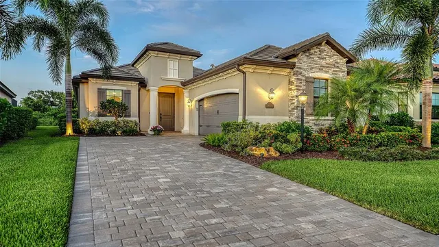 a front view of a house with a yard and potted plants