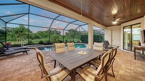 a view of a roof deck with table and chairs under an umbrella with a small yard