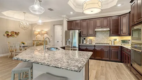 a kitchen with stainless steel appliances granite countertop a sink refrigerator and cabinets