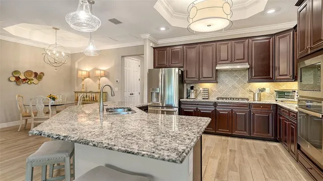 a kitchen with stainless steel appliances granite countertop a sink refrigerator and cabinets