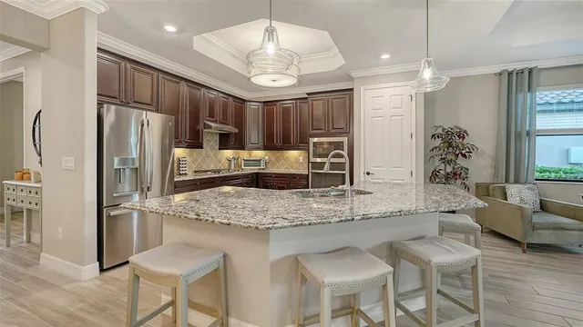 a kitchen with stainless steel appliances granite countertop a sink refrigerator and cabinets