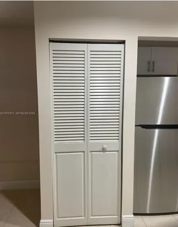 a view of kitchen with refrigerator and cabinet