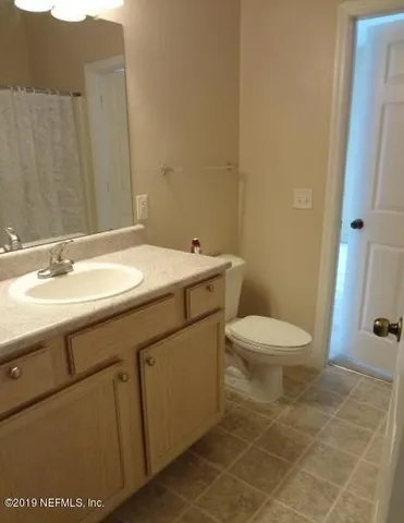 a bathroom with a sink a toilet and a mirror