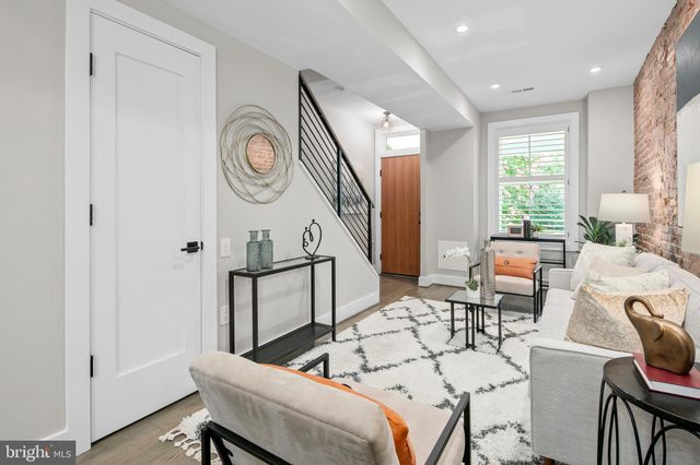 a living room with furniture wooden floor and a potted plant