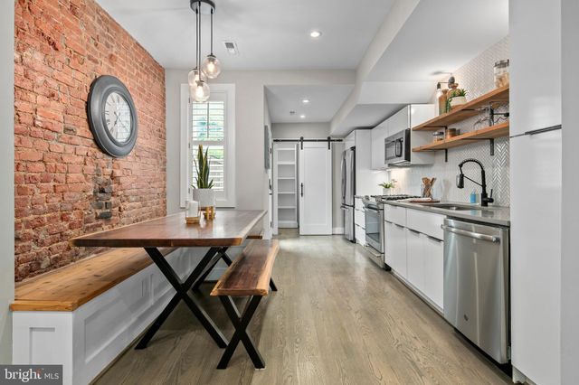 a large open kitchen with stainless steel appliances granite countertop a lot of counter space and a dining table