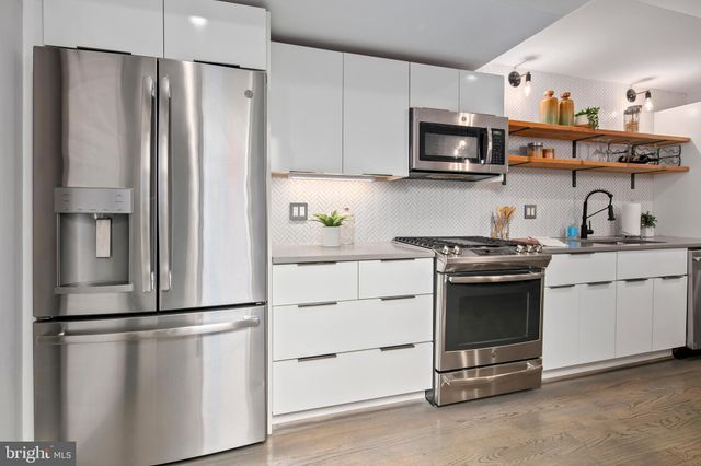 a kitchen with stainless steel appliances a refrigerator and a stove top oven