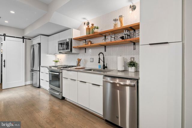 a kitchen with stainless steel appliances a sink and cabinets