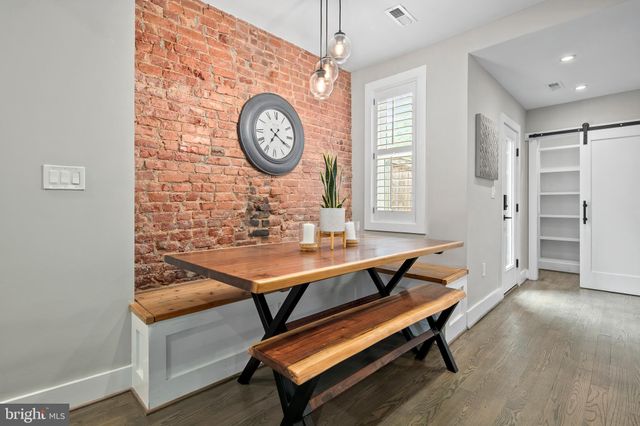 a living room with couch chairs and a clock on it