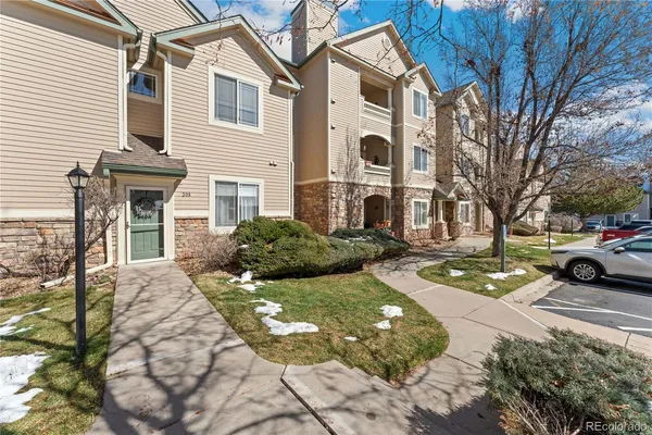 a view of a white house next to a yard