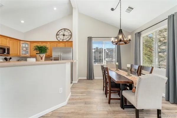 a dining room with furniture a chandelier and wooden floor