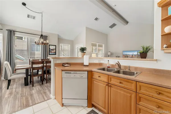 a kitchen with cabinets a sink appliances and a dining table