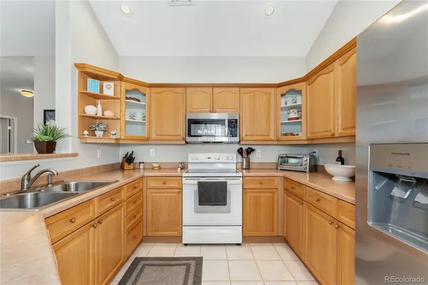 a kitchen with a sink stove top oven and refrigerator