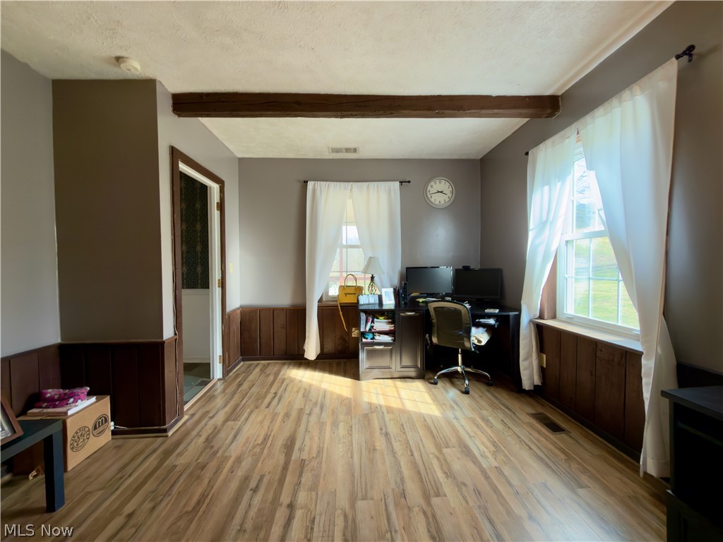 17377 Murphy Road Amesville, OH 45711 - Photo 18 of 43 Office with beam ceiling, a wainscoted wall, light wood-type flooring, wood walls, and a textured ceiling