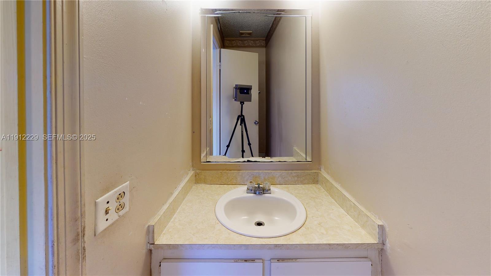 5130 Elmhurst Road, Unit H West Palm Beach, FL 33417 - Photo 7 of 15 a bathroom with a sink and a mirror