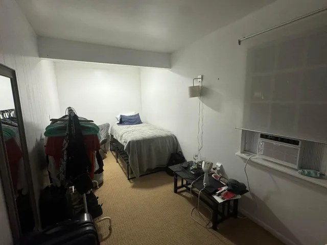 a bedroom with bed a couch and dresser