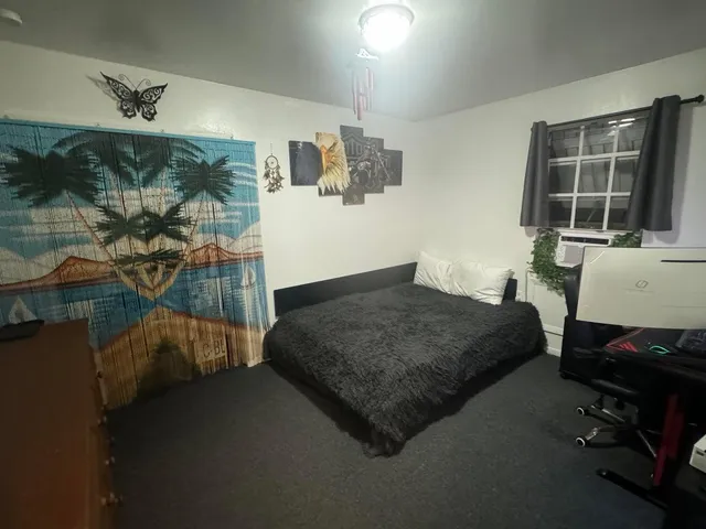 a spacious bedroom with a bed and a window