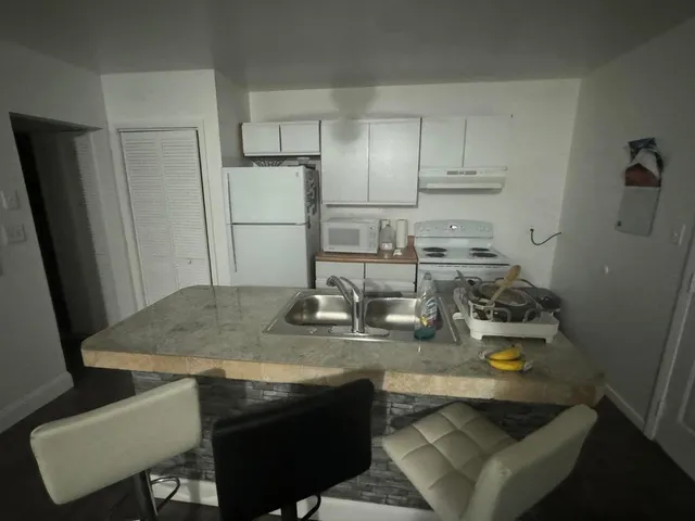 a kitchen with sink and refrigerator