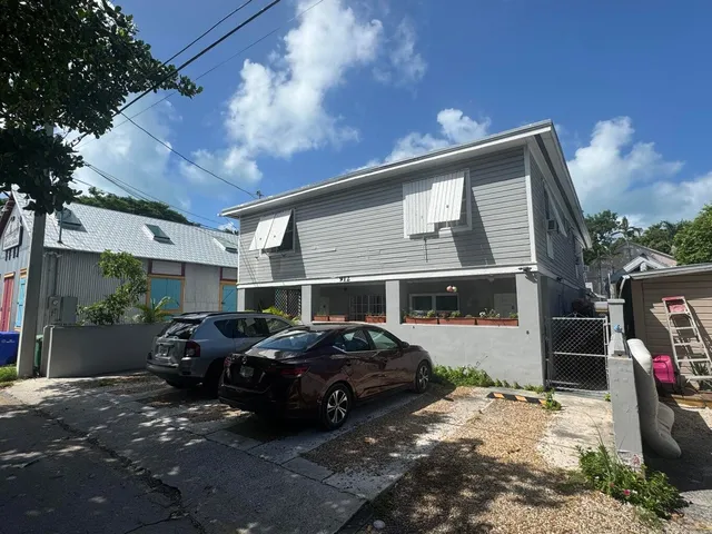 a front view of a house with cars parked