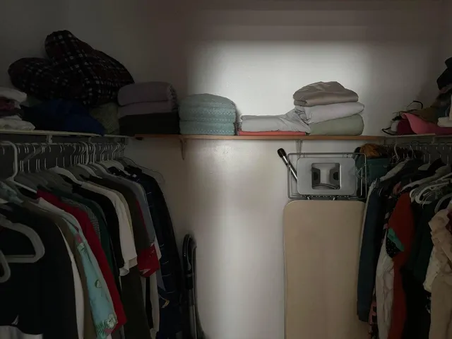 a view of walk in closet with clothes and shoes