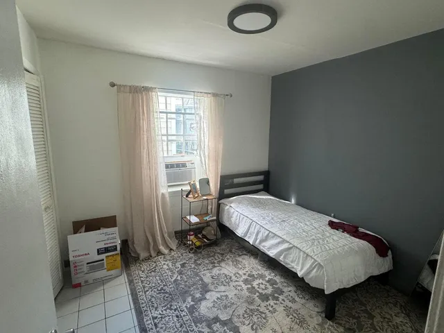 a bedroom with a bed and a window