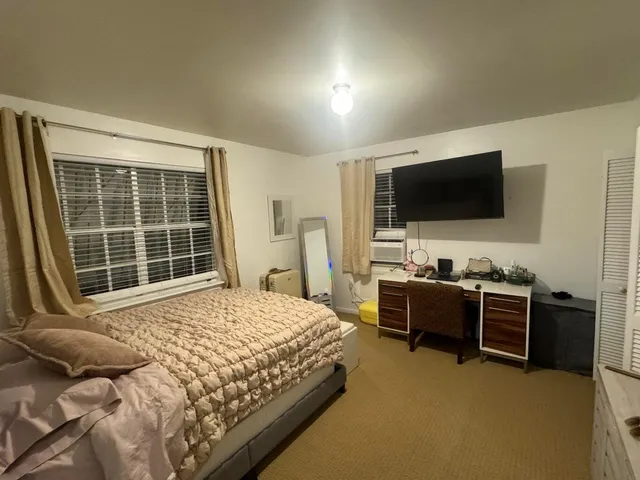 a bedroom with a bed and a flat screen tv