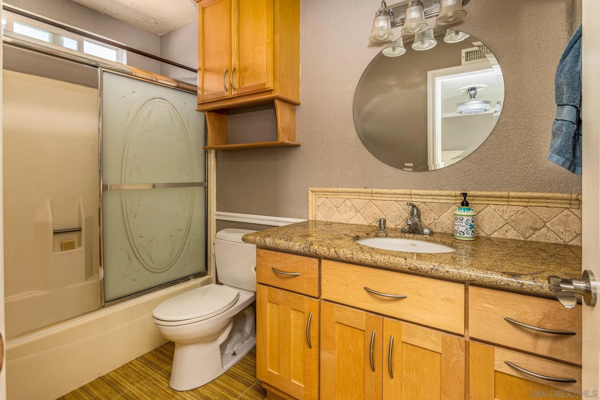 532 Kempton Street Spring Valley, CA 91977 - Photo 18 of 30 a bathroom with a granite countertop sink mirror vanity and toilet